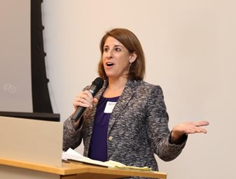woman speaking into microphone at podium